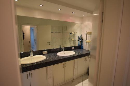 uma casa de banho com 2 lavatórios e um espelho grande em Skandinavienblick-1-5-Strandstern em Hohwacht