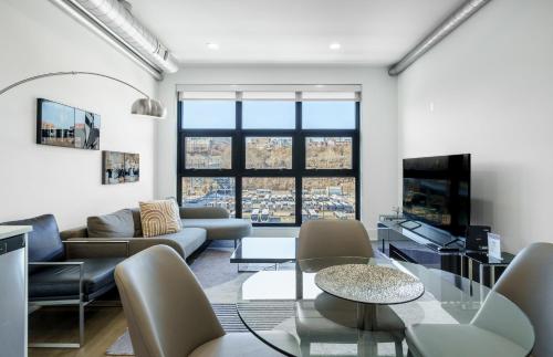 a living room with a couch and a tv at Dharma Home Suites Hoboken in Hoboken