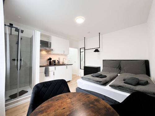 ein Schlafzimmer mit einem Bett und einem Tisch sowie eine Küche in der Unterkunft Cityapartments Düsseldorf - Stadtmitte in Düsseldorf