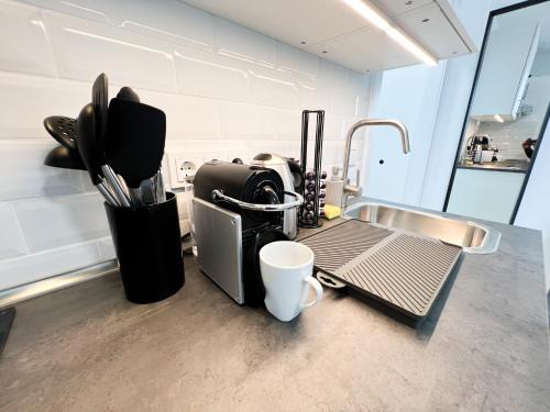 a kitchen counter with a coffee maker next to a sink at Cityapartments Düsseldorf - Stadtmitte in Düsseldorf