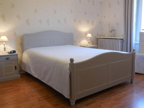 ein Schlafzimmer mit einem weißen Bett und zwei Nachttischen in der Unterkunft Gîte Saint-Dié-des-Vosges, 2 pièces, 2 personnes - FR-1-589-177 in Saint Die