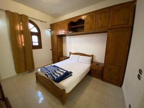 um quarto com uma cama e armários de madeira em Red oasis em Dahab