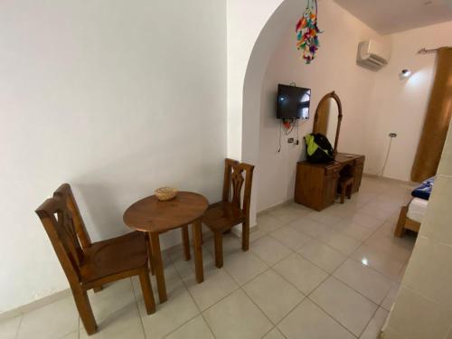 um quarto com uma mesa e cadeiras e uma televisão em Red oasis em Dahab