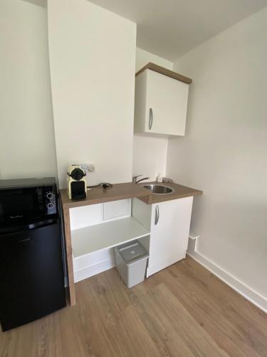 une petite cuisine avec un évier et un réfrigérateur dans l'établissement Cocoon Meridien, à Paris