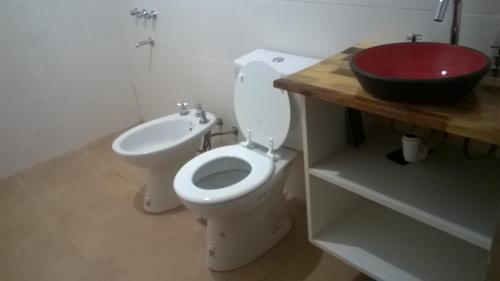 y baño con aseo blanco y lavabo rojo. en MADRESELVA en San Rafael