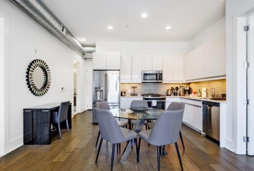 a kitchen with white cabinets and a table and chairs at Dharma Home Suites Hoboken in Hoboken