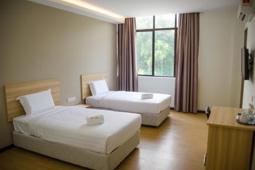 Un pat sau paturi într-o cameră la 1 Orange Hotel Sungai Buloh