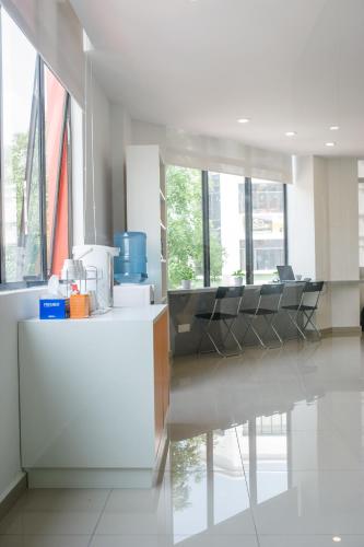 a living room with chairs and a table and windows at 1 Orange Hotel Sungai Buloh in Sungai Buluh