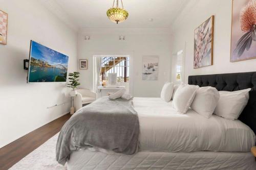 um grande quarto branco com uma grande cama branca em Lovely Apartment in Darlinghurst em Sydney