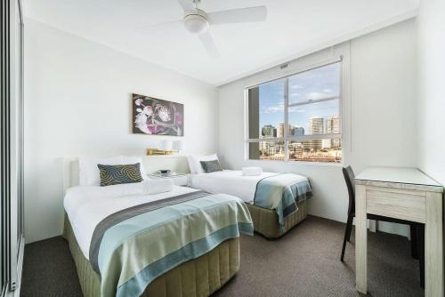 a hotel room with two beds and a window at Harbourside #32 in Sydney