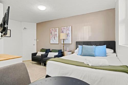 - une chambre avec un grand lit et des oreillers bleus dans l'établissement The Great Escape, Paddington apartment, à Sydney