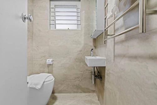 La salle de bains est pourvue de toilettes, d'un lavabo et d'une fenêtre. dans l'établissement The Great Escape, Paddington apartment, à Sydney