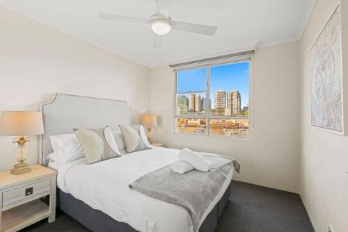 a bedroom with a white bed and a window at Harbourside #31 in Sydney