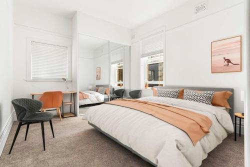 a bedroom with two beds and a desk and chairs at Spacious Boutique Apartment in Beautiful Art Deco Block in Sydney