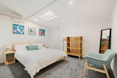 a bedroom with a bed and a blue chair at Cosy Camperdown in Sydney