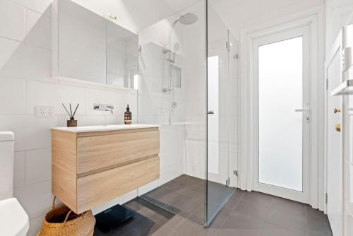 a white bathroom with a sink and a shower at Bright Home in Trendy Newtown close to the Park in Sydney