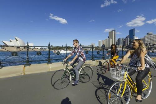 a group of people riding bikes on a bridge at Terrace Boutique in the Heart of The Rocks in Sydney