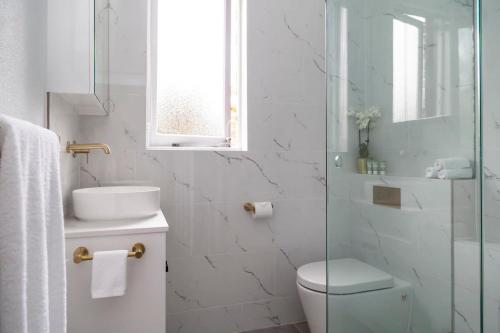 uma casa de banho com um WC, um lavatório e um chuveiro em Woollahra Wonder em Sydney