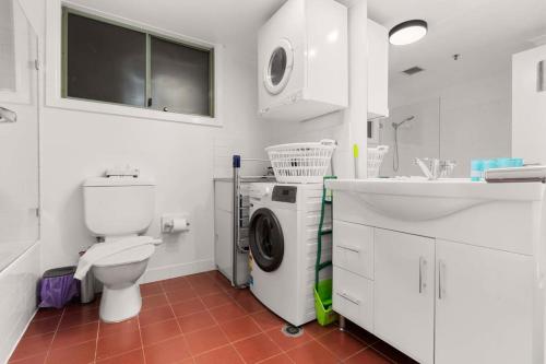 a bathroom with a toilet and a washing machine in it at 1 BR Apartment In the Heart of Darling Harbour in Sydney