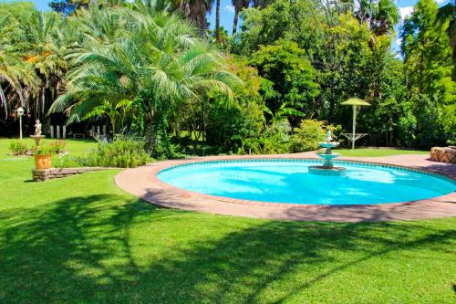 una piscina en un patio con una fuente en Three Gables Guesthouse en Upington
