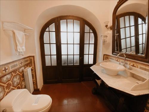 W łazience znajduje się umywalka, toaleta i lustro. w obiekcie Parador Santa Maria La Real w mieście Sucre