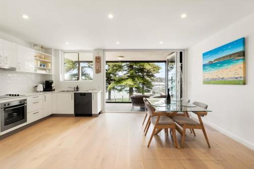 a kitchen and dining room with a table and chairs at Stylish Manly Apartment with Harbour Views in Sydney