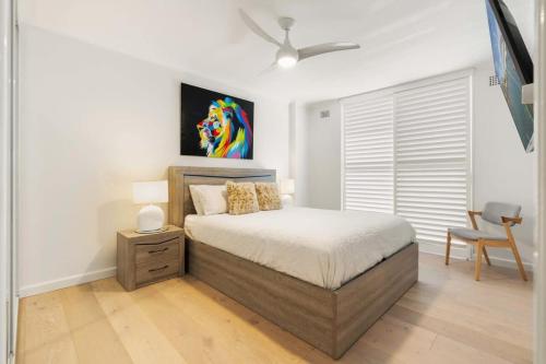 a bedroom with a bed and a painting on the wall at Stylish Manly Apartment with Harbour Views in Sydney