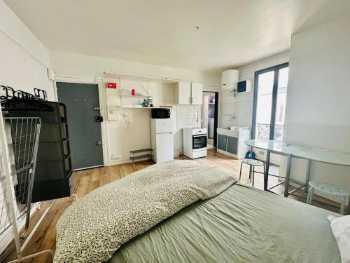 une chambre avec un lit et une cuisine avec une table dans l'établissement Parfait studio central, à Paris