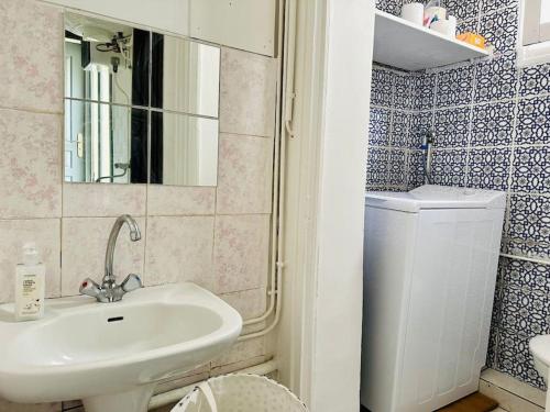 une salle de bain avec un lavabo et une machine à laver dans l'établissement Parfait studio central, à Paris