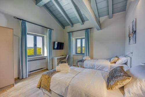 - 2 lits dans une chambre avec 2 fenêtres dans l'établissement Villa Stara Hiza, à Novaki Pazinski