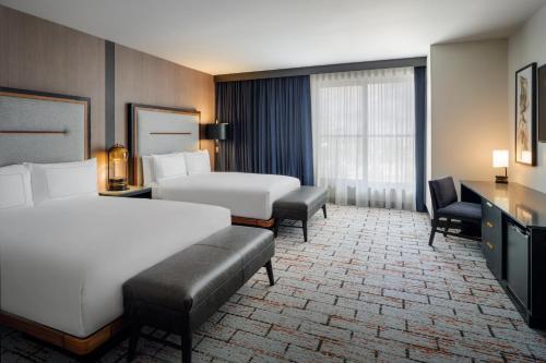 a hotel room with two beds and a desk at The Hoffmann Hotel Basalt Aspen Tapestry Collection Hilton in Basalt