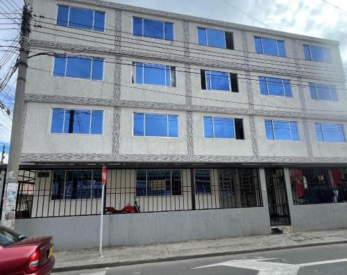 um grande edifício com muitas janelas numa rua em Departamento amoblado en Kennedy central em Bogotá