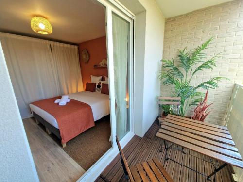 ein Hotelzimmer mit einem Bett und einer Bank in der Unterkunft L'Hacienda / F2 de standing Cergy /parking inclus in Cergy