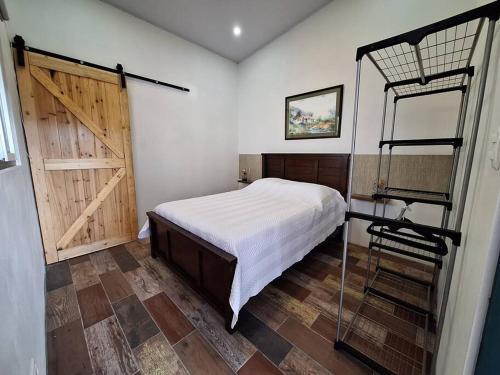 1 dormitorio con 1 cama y 1 litera con puerta en Casa de las Brujas Escazú, en Escazú