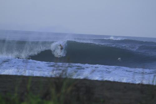 a surfer is riding a wave in the ocean at The captains iin in Chinandega