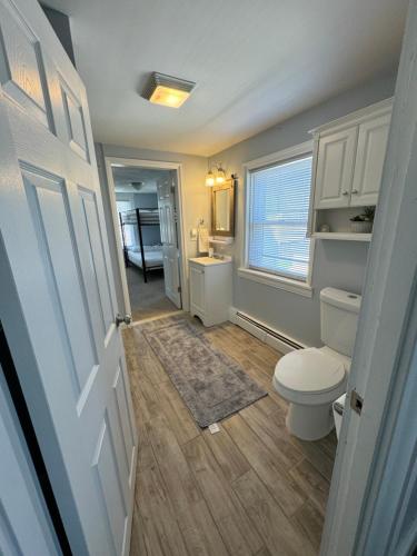 een badkamer met een toilet, een wastafel en een raam bij Little Rhody in Pawtucket