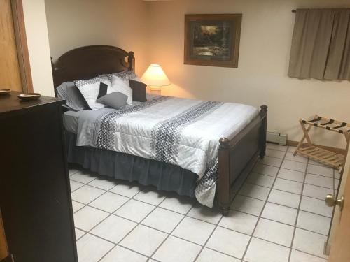 a bedroom with a bed and a lamp on a tiled floor at West Main Lodge, 2 Bedrooom in Lead