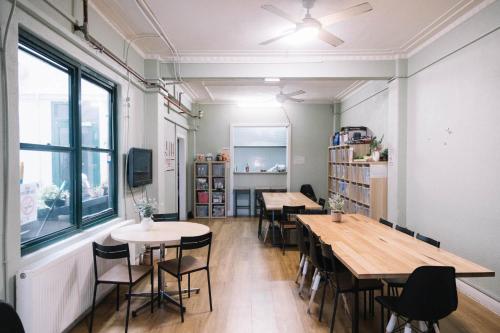 une chambre avec des tables, des chaises et une fenêtre dans l'établissement CarricHostel, à Melbourne