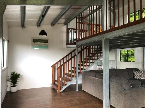 a living room with a couch and a staircase at Daintree - House with a view in Cow Bay