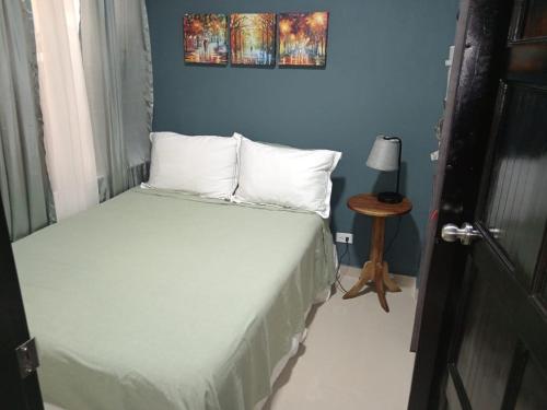 a bedroom with a bed and a blue wall at Apartamentos Ave del Paraíso in Alajuela City