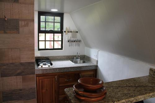 a kitchen with a sink and a counter with a window at Cabañas La Encantada 