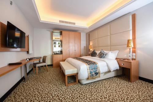 Grand Park by VERTA في جدة: غرفة في الفندق مع سرير ومكتب