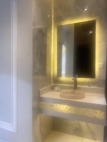een badkamer met een wastafel en een spiegel bij فله روف خاصه in Tabuk