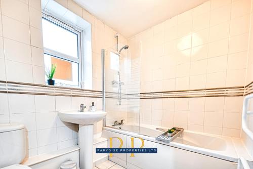 a bathroom with a sink and a toilet and a tub at The Sale Symphony Suite - By Parydise Properties - Business or Leisure Stays - Sleeps 6 - Sale, Manchester in Sale