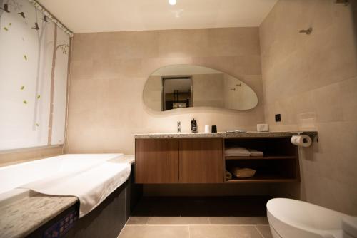 永康區的住宿－晶盈親旅大酒店 ，带浴缸、水槽和浴缸的浴室