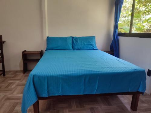 een bed met een blauw dekbed in een slaapkamer bij Jungle house in Cocles