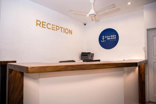 a reception desk with a sign on the wall at Sailors Beach Fiji in Nadi