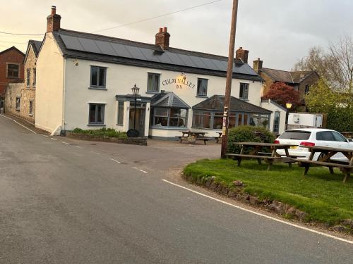 a white building on the side of a street at Piglet Corner in Culmstock