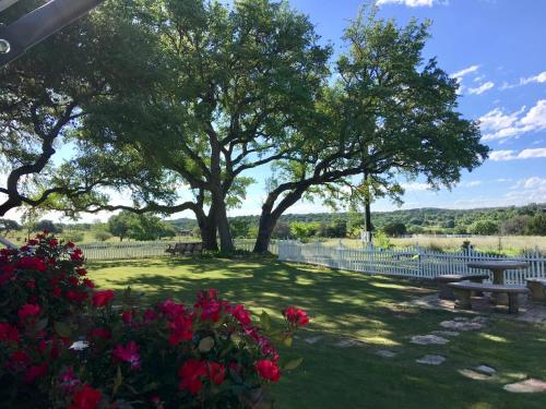 a park with two benches and flowers and trees at The Alexander at Creek Road in Dripping Springs