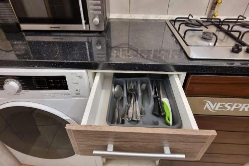 a kitchen drawer with utensils in it next to a stove at Ultracentral Residence 6 in Ploieşti